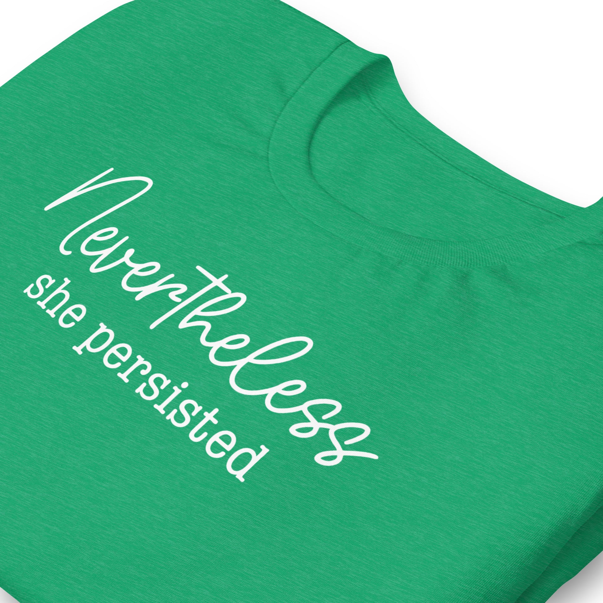 Close-up of heather green unisex t-shirt showing handwritten script typography reading “Nevertheless she persisted,” feminist equality activist clothing.