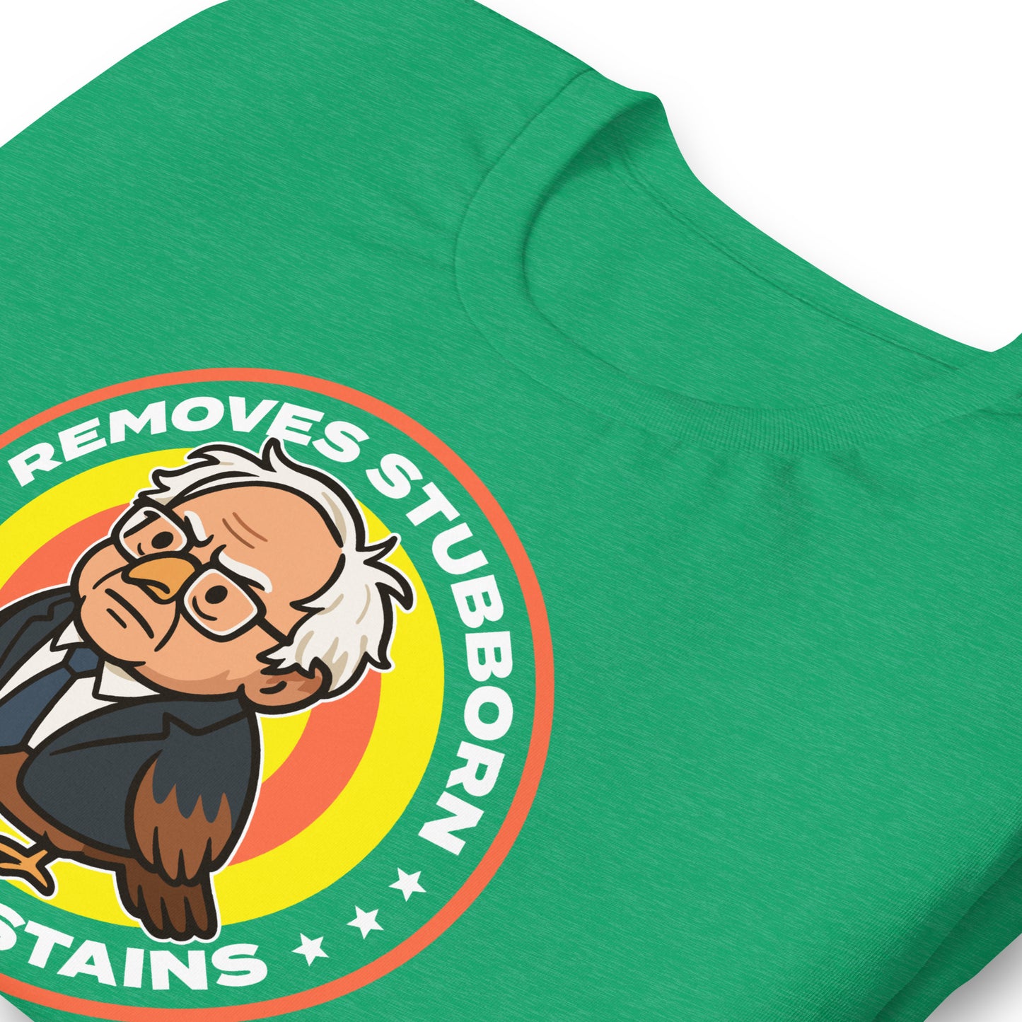 Close-up heather kelly green unisex T-shirt print showing Birdie Sanders detergent parody badge and “Removes Stubborn Orange Stains” slogan detail.