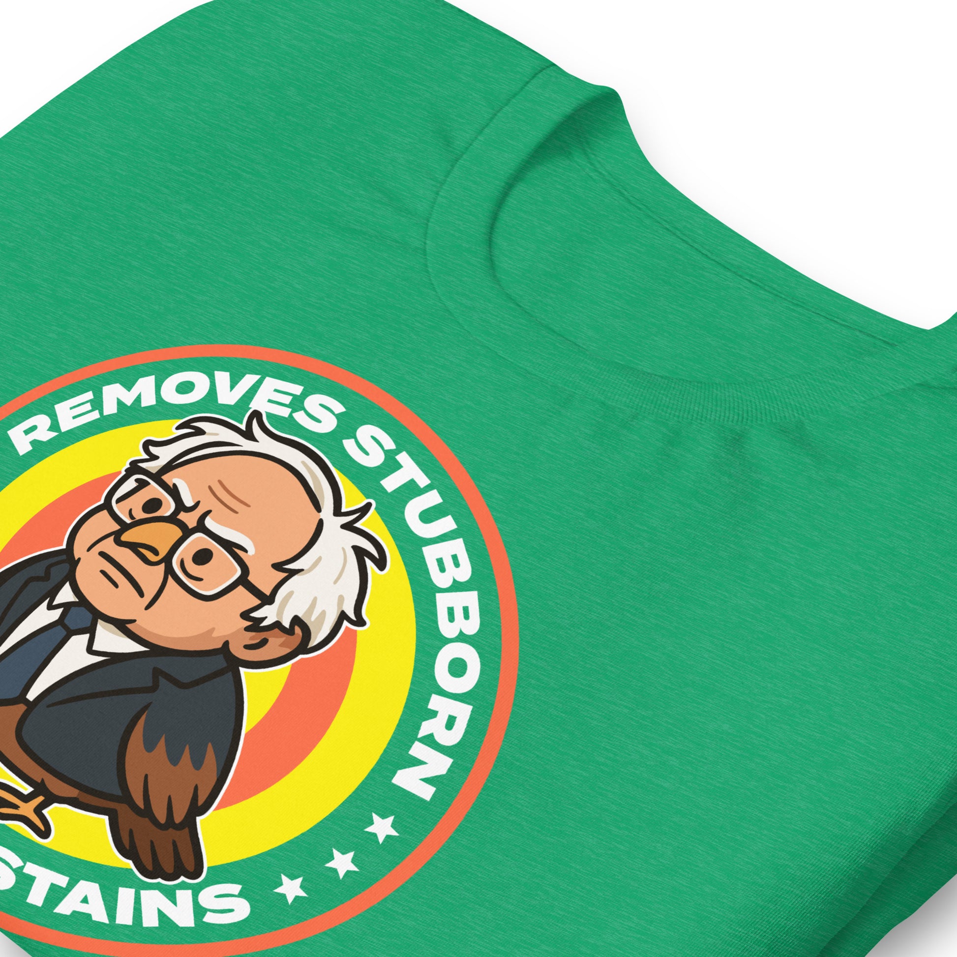 Close-up heather kelly green unisex T-shirt print showing Birdie Sanders detergent parody badge and “Removes Stubborn Orange Stains” slogan detail.