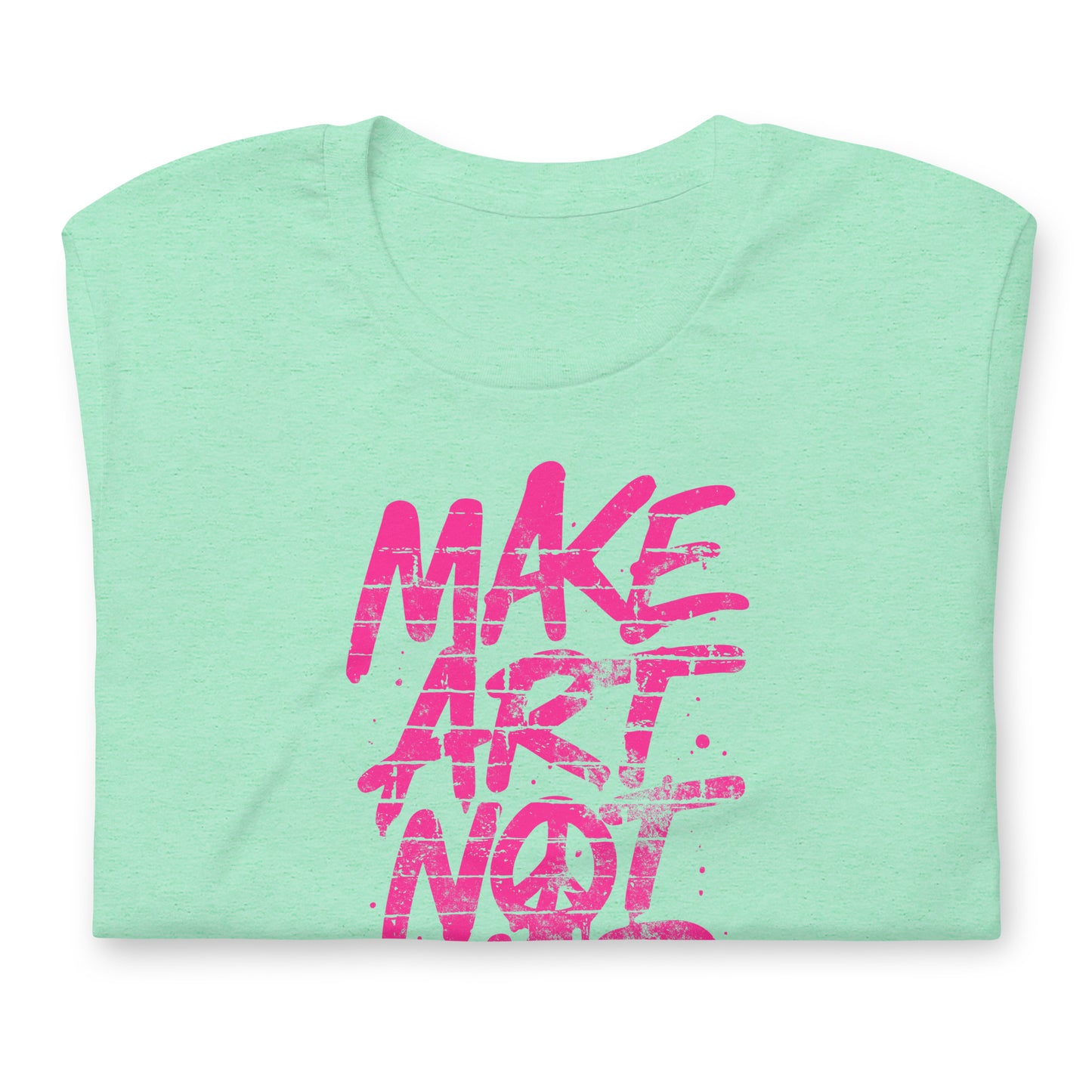 Folded heather mint green unisex t-shirt showing partial neon pink graffiti lettering from the phrase “MAKE ART NOT WAR,” emphasizing bold brushstroke texture and high-contrast street-art graphic style.
