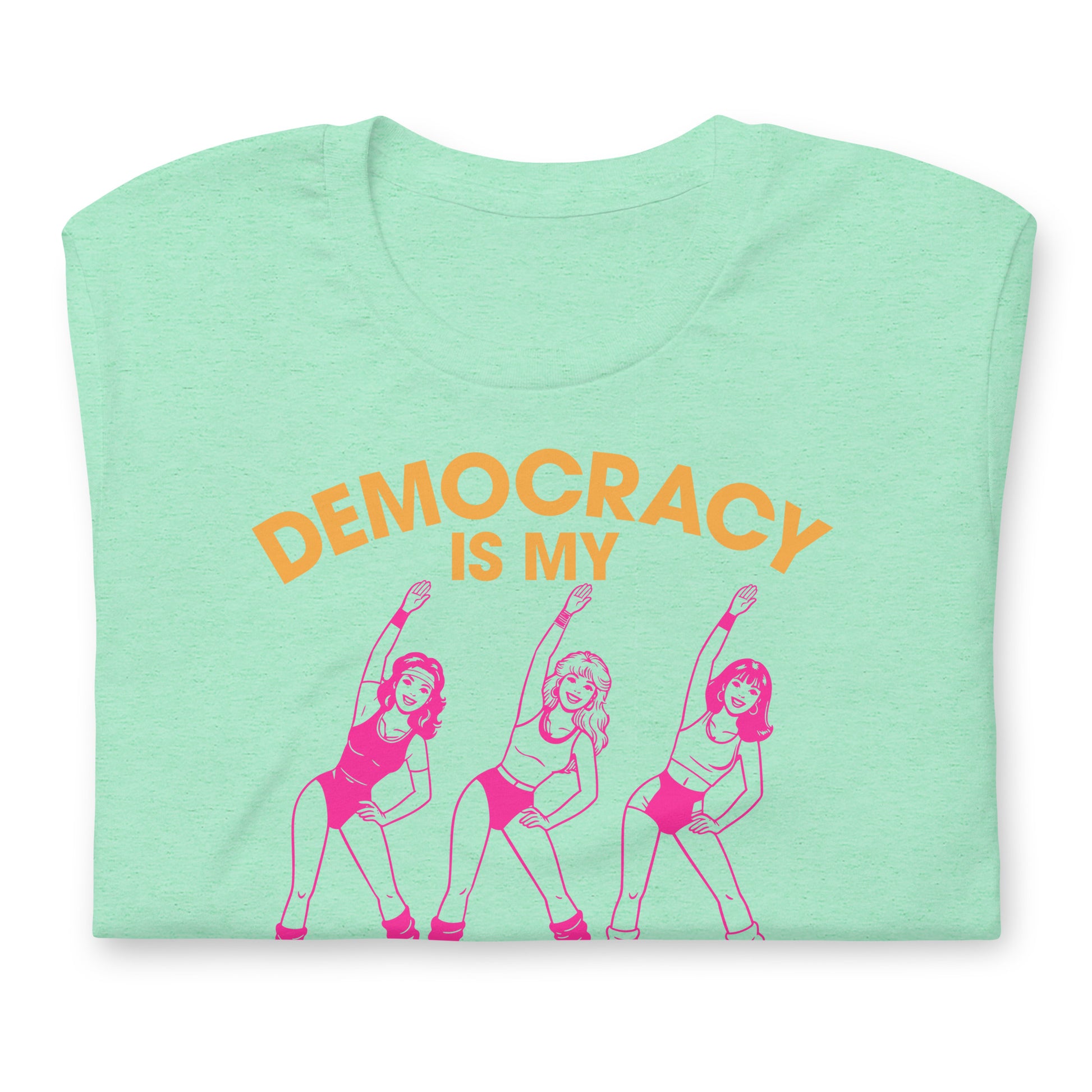 Folded heather mint unisex T-shirt displaying vintage pink workout dancers beneath “Democracy Is My” text with bold cardio lettering.
