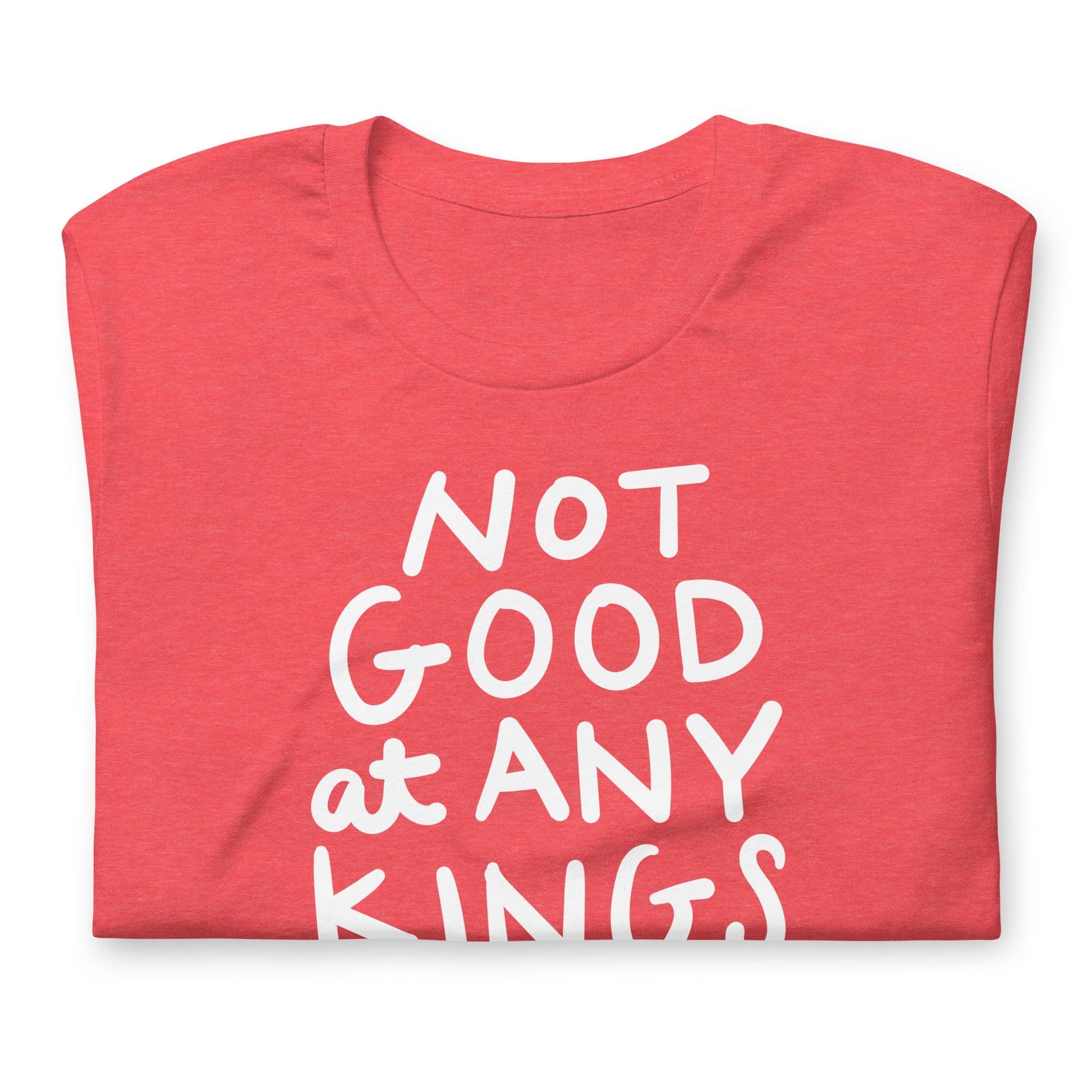 Folded heather red unisex t-shirt featuring white lettering reading “NOT GOOD AT ANY KINGS” with crown symbol.