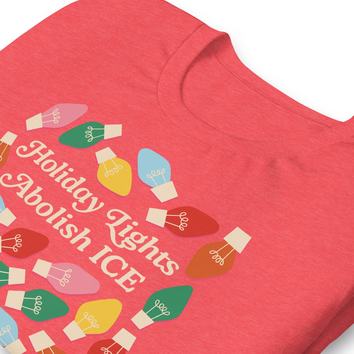 A close-up of heather red t-shirt fabric showing bright holiday bulbs surrounding the message “Holiday Lights Abolish ICE,” emphasizing print detail and festive activist colors from Blue Wave USA.