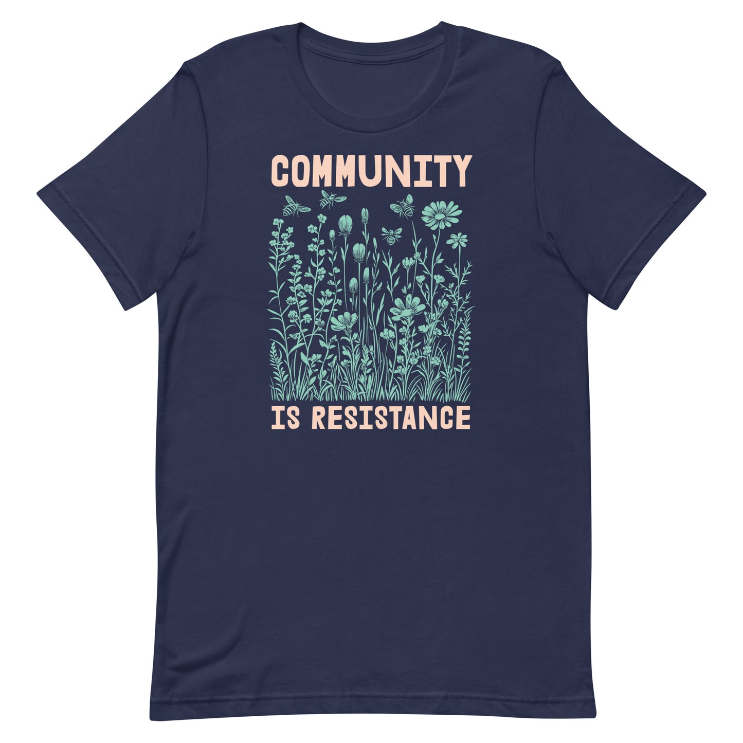 Navy blue Community Is Resistance shirt with mint-green floral artwork and cream lettering. A refined activist piece blending art, ecology, and justice.