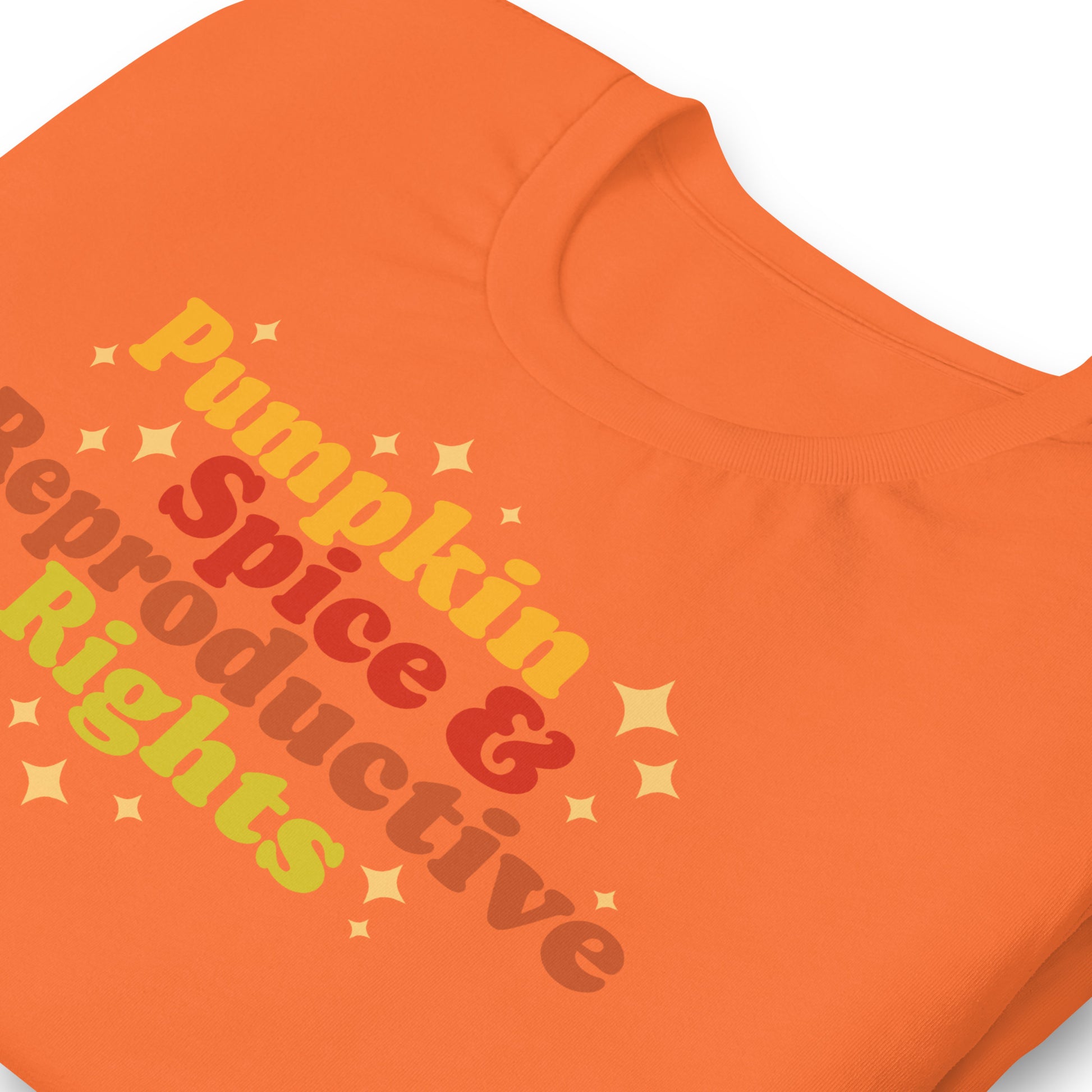 Orange unisex t-shirt close-up featuring retro typography reading “Pumpkin Spice & Reproductive Rights,” pro-choice fall activist apparel.