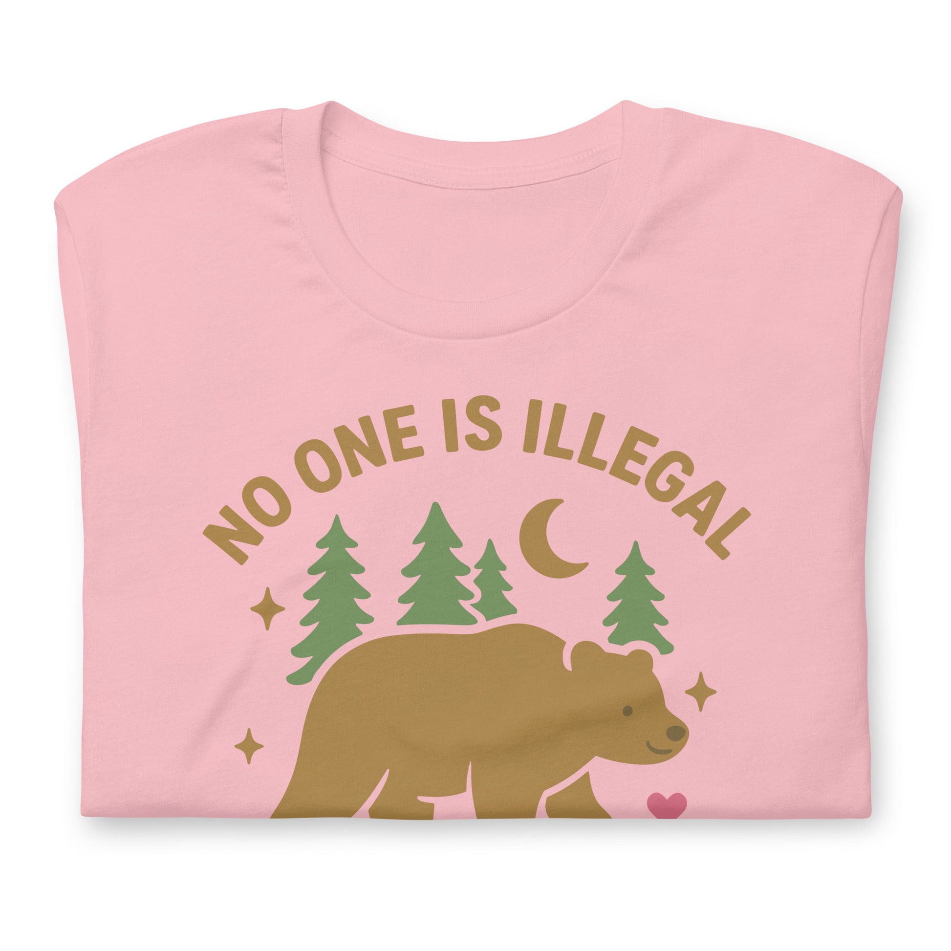 Pink unisex t-shirt with a tan bear illustration, forest silhouettes, and the text “NO ONE IS ILLEGAL ON STOLEN LAND,” styled in warm, nature-themed colors.
