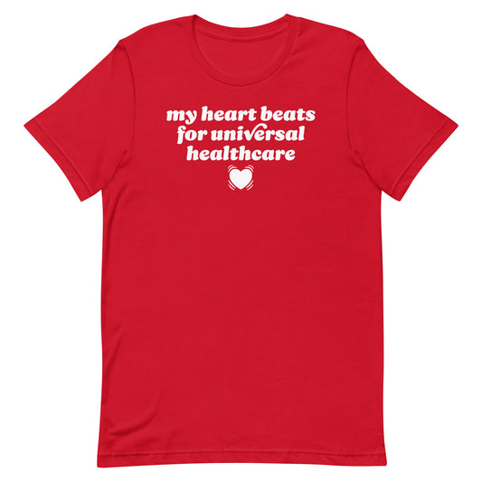 Red unisex t-shirt displaying “my heart beats for universal healthcare” in bold lettering, a progressive Valentine statement advocating compassion, care, and universal medical access.