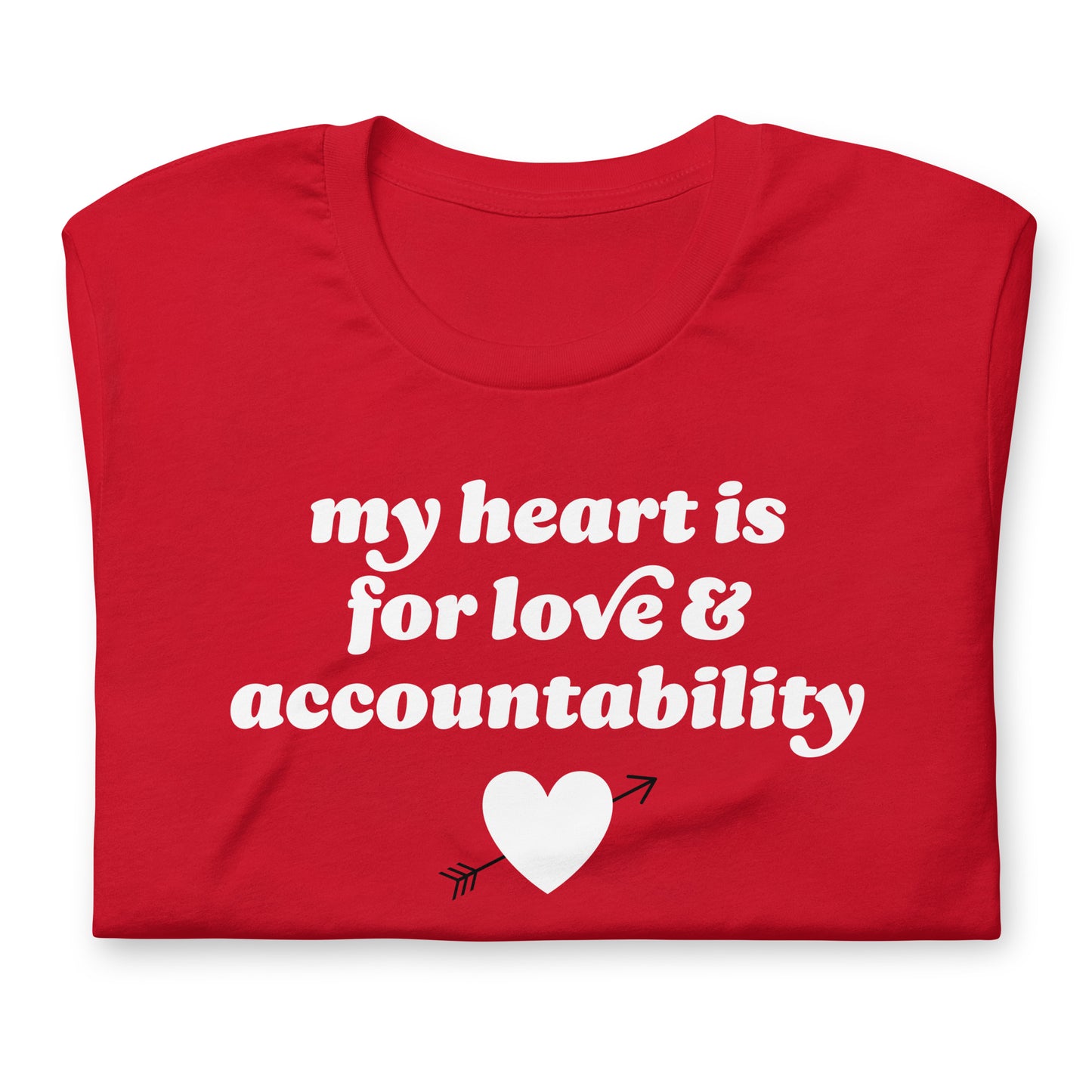 Folded red unisex t-shirt close-up featuring the phrase “my heart is for love & accountability” with heart icon, a simple progressive Valentine statement.