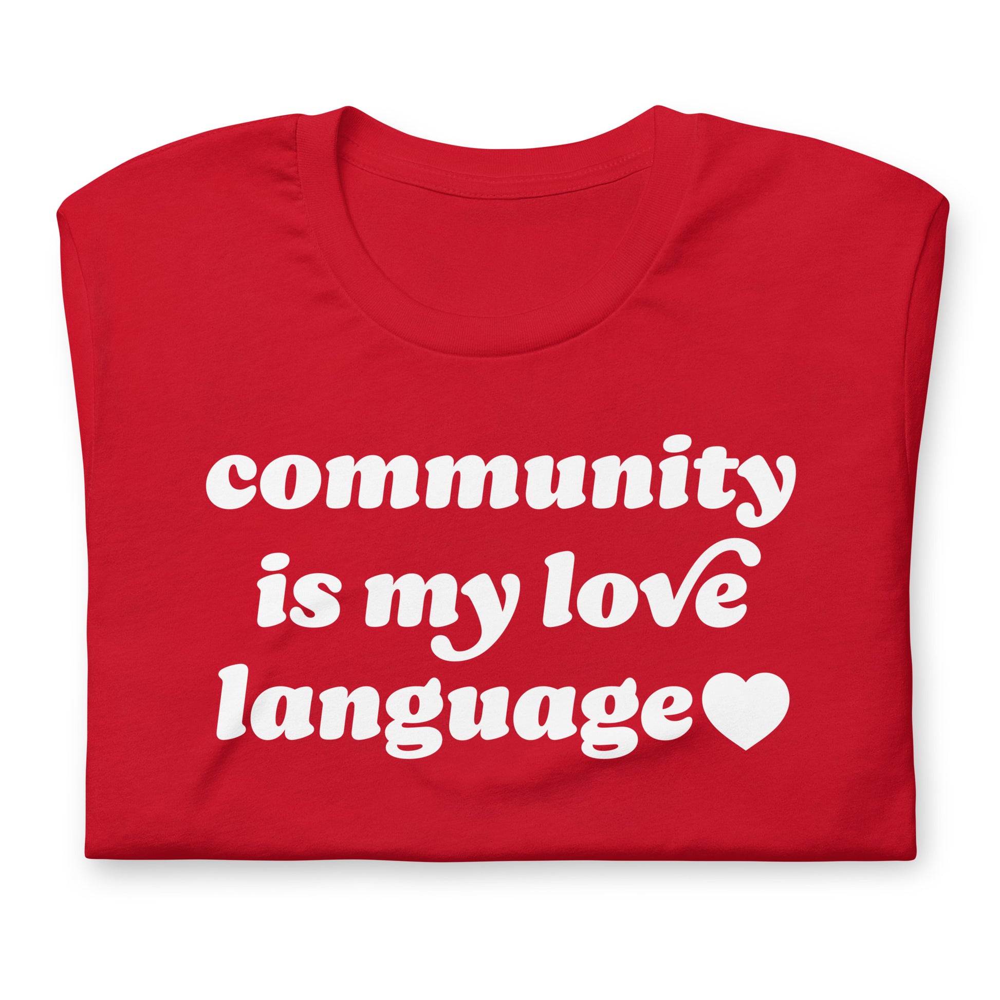 Folded unisex t-shirt highlighting vintage red typography and heart graphic with the phrase “community is my love language,” close-up product detail view.