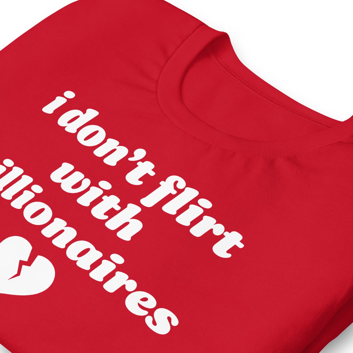 Close-up of red unisex t-shirt collar and print showing the phrase “i don’t flirt with billionaires” with a small broken heart graphic.