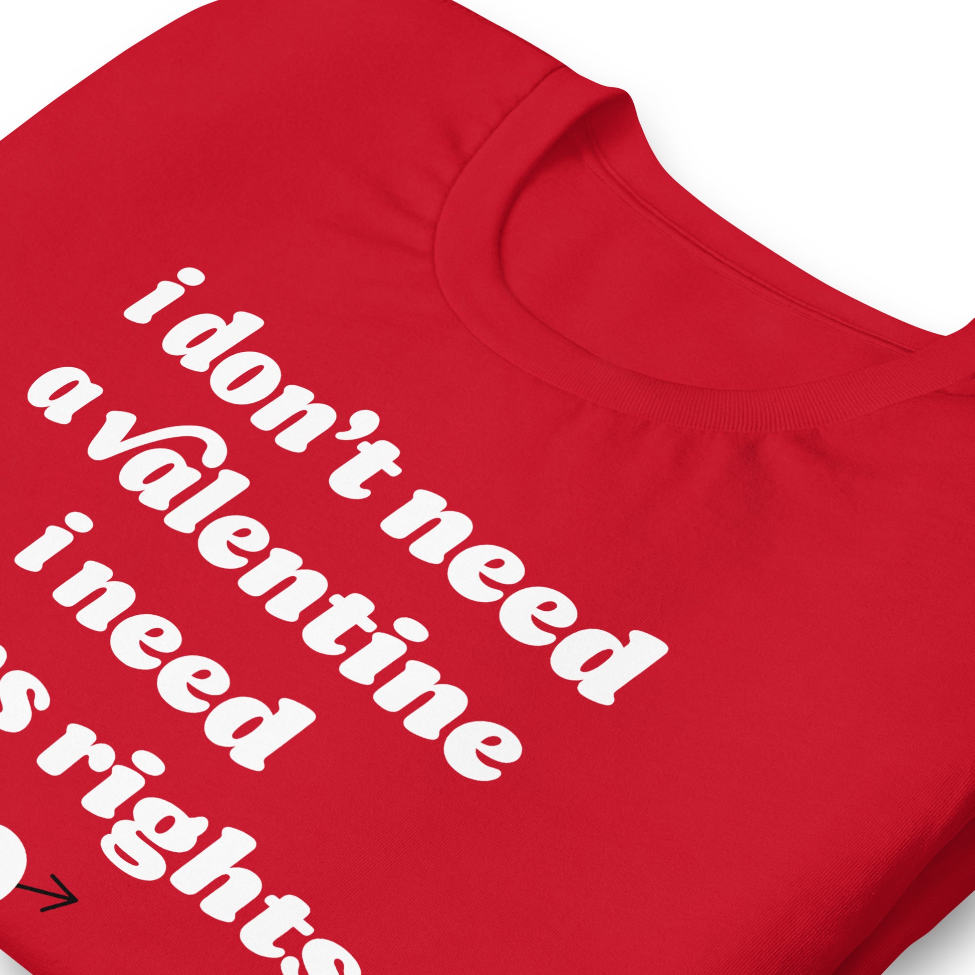 Close-up detail of red t-shirt fabric highlighting the phrase “i don’t need a valentine i need trans rights,” emphasizing bold typography and Valentine activist style.