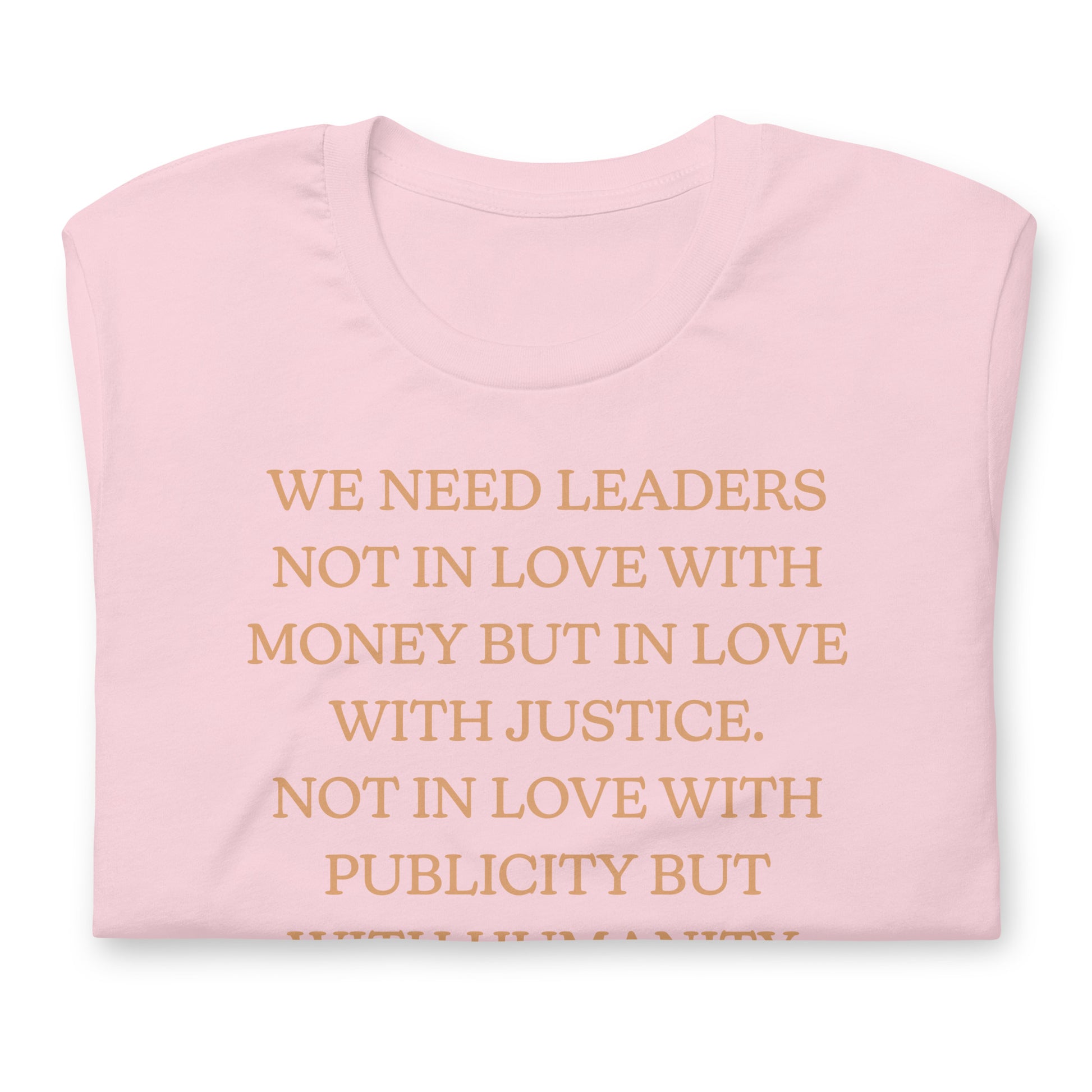 Pink shirt featuring the MLK quote “WE NEED LEADERS NOT IN LOVE WITH MONEY BUT IN LOVE WITH JUSTICE… WITH HUMANITY.” A gentle activist design centered on justice and leadership.