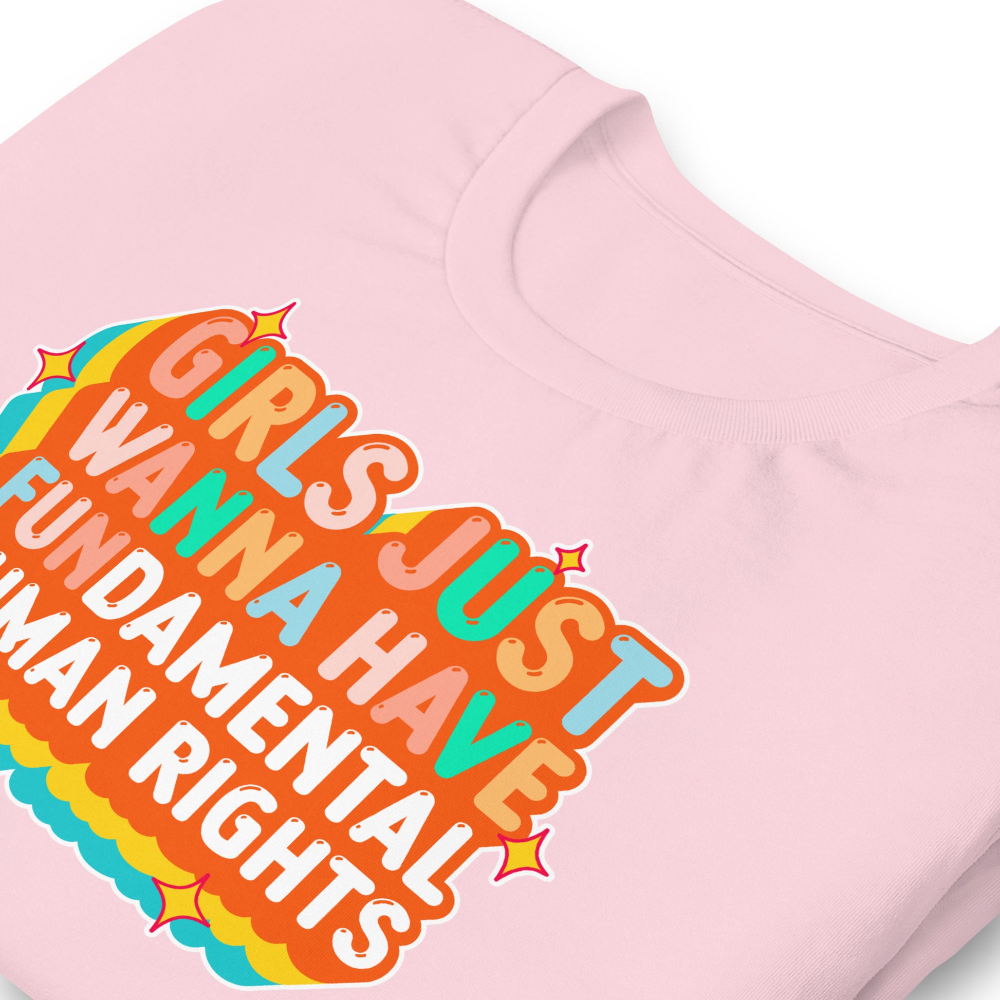 Close-up of pastel pink t-shirt showing wavy layered orange text and teal outline around the feminist slogan. Vibrant retro-style activism design.