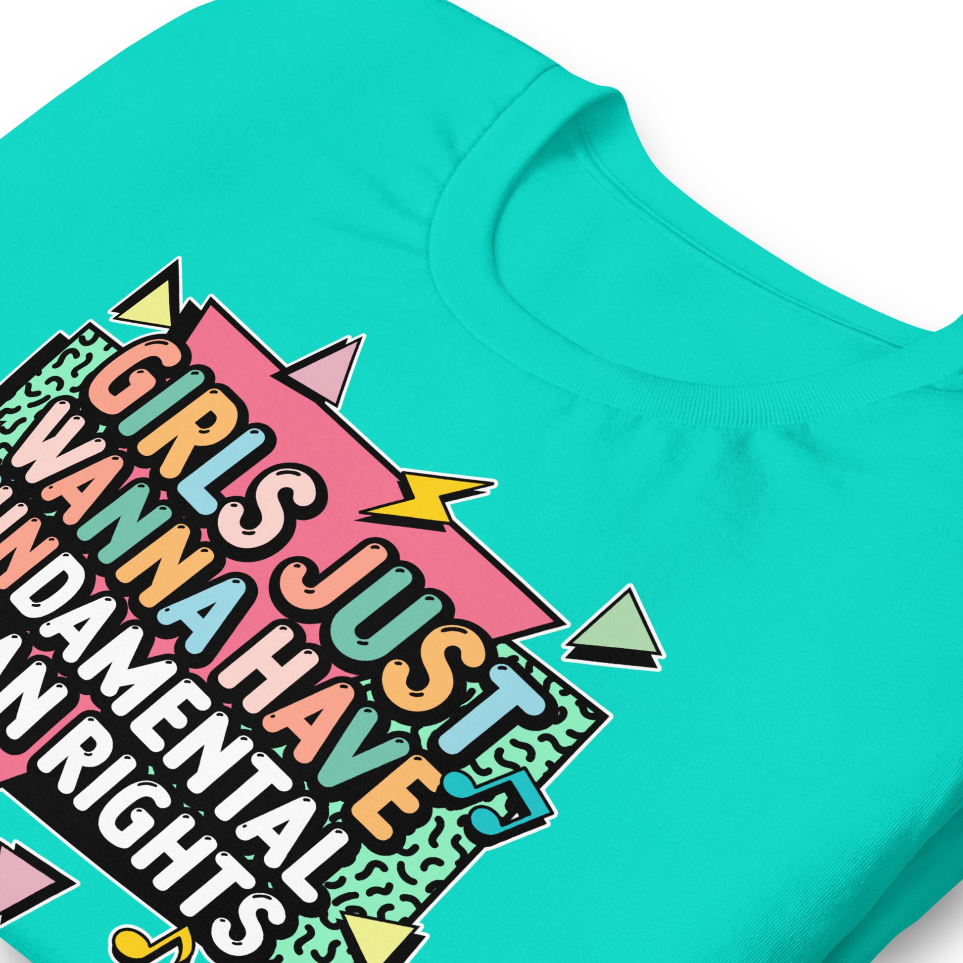 Close-up of teal t-shirt with pastel lightning bolts and the retro feminist slogan “Girls Just Wanna Have Fundamental Human Rights.” Progressive activist design by Blue Wave USA.