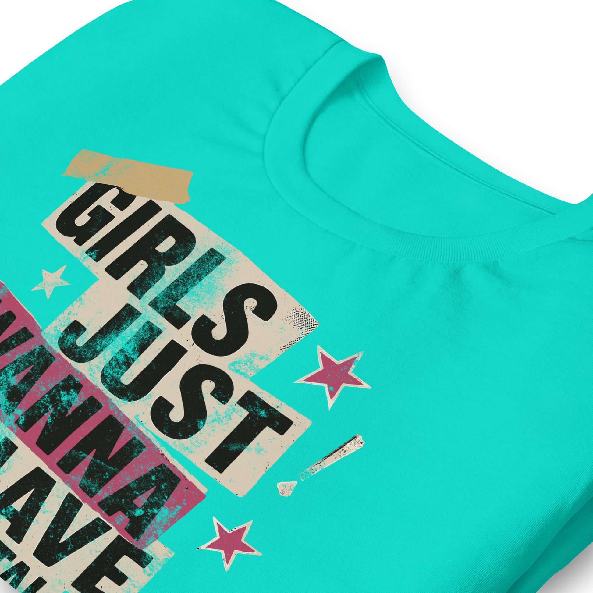 Folded teal unisex shirt with punk collage lettering reading “Girls Just Wanna Have Fundamental Human Rights.” Feminist activist apparel in bright modern tones.