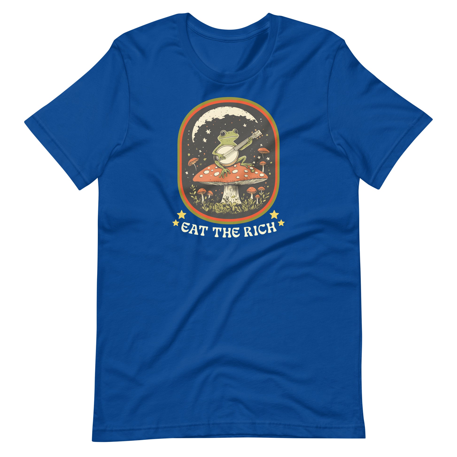 Royal blue unisex t-shirt featuring a whimsical banjo-playing frog graphic with folk-art aesthetics and anti-capitalist “Eat The Rich” typography.