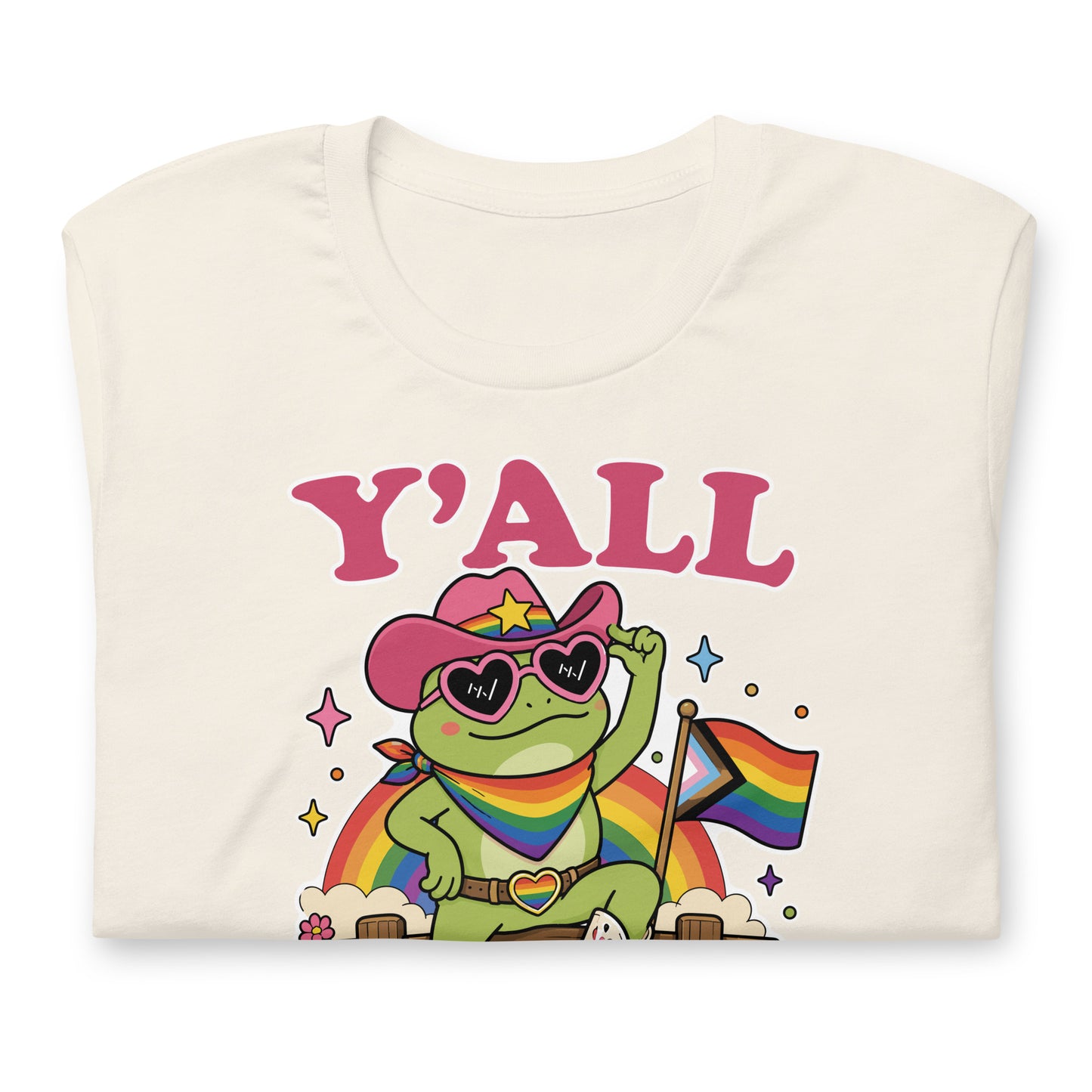 Folded vintage white LGBTQ+ pride t-shirt displaying a rainbow cowboy frog holding a pride flag with colorful western-inspired “Y’All Means All” design.