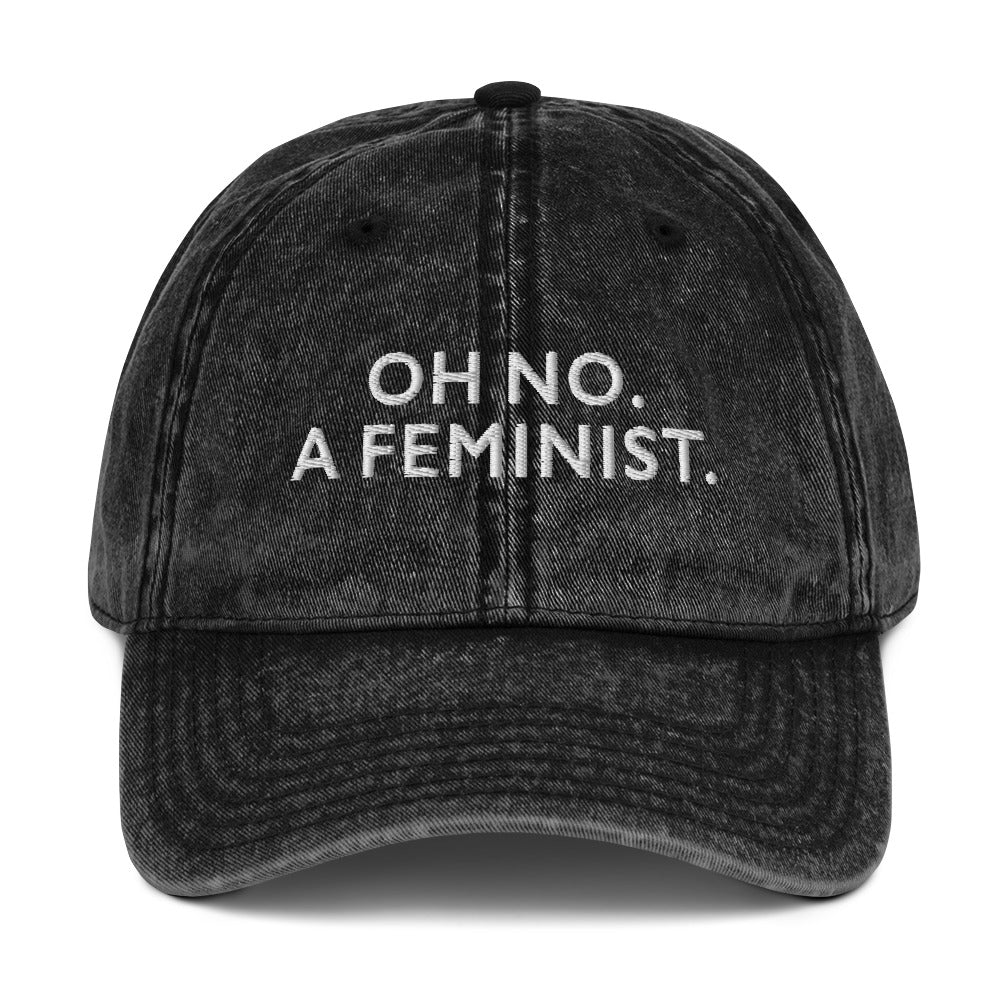 Black vintage embroidered cap featuring the phrase “OH NO. A FEMINIST.” in bold white lettering, a minimalist feminist design with a playful, unapologetic message.