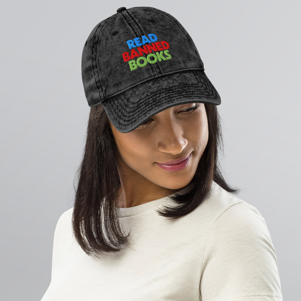 Person wearing a black vintage cap embroidered with the colorful “Read Banned Books” design for readers, librarians, and anti-censorship advocates.
