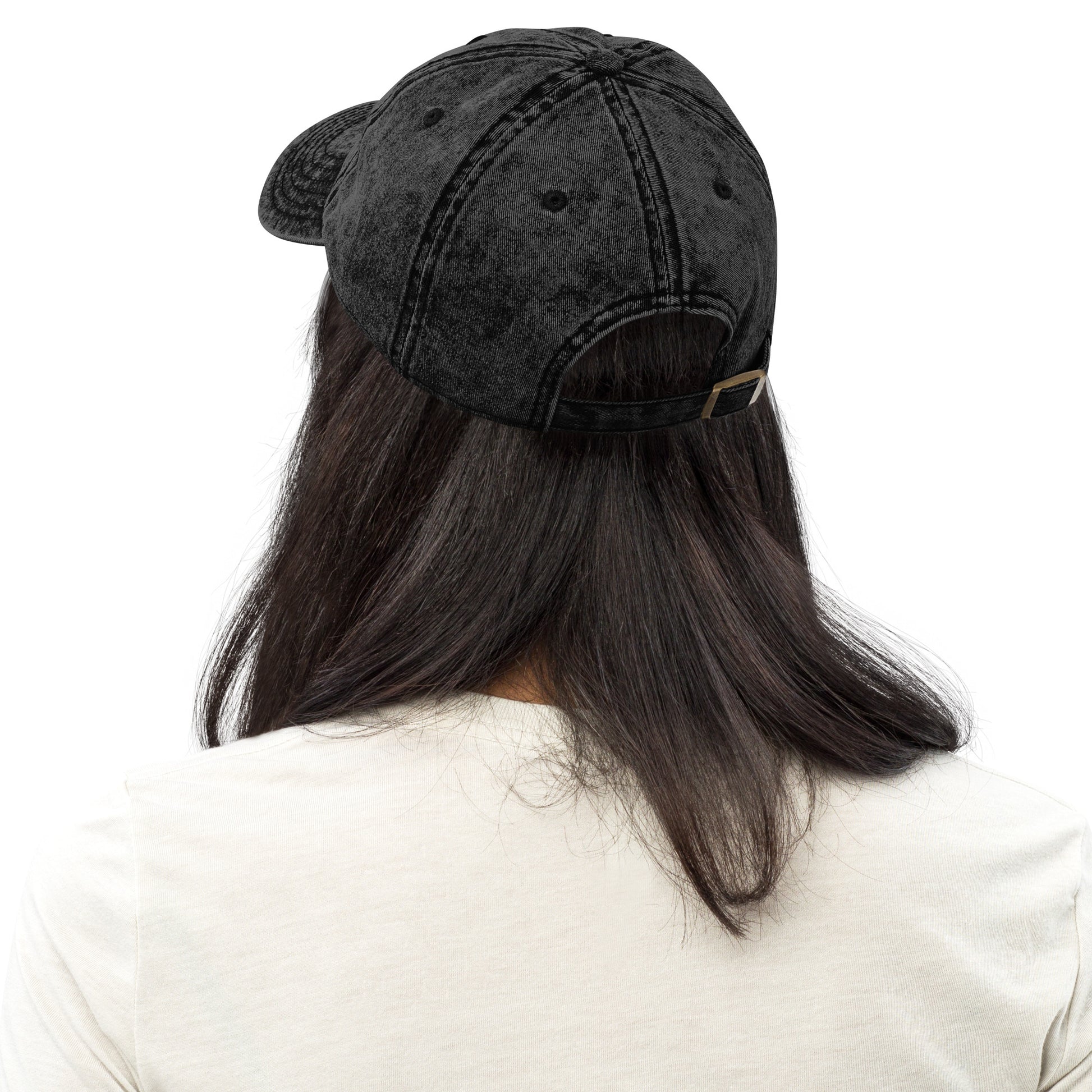 Back view of a black vintage cotton twill cap worn by a model, showing unstructured crown, adjustable strap, and subtle washed finish from Blue Wave USA.