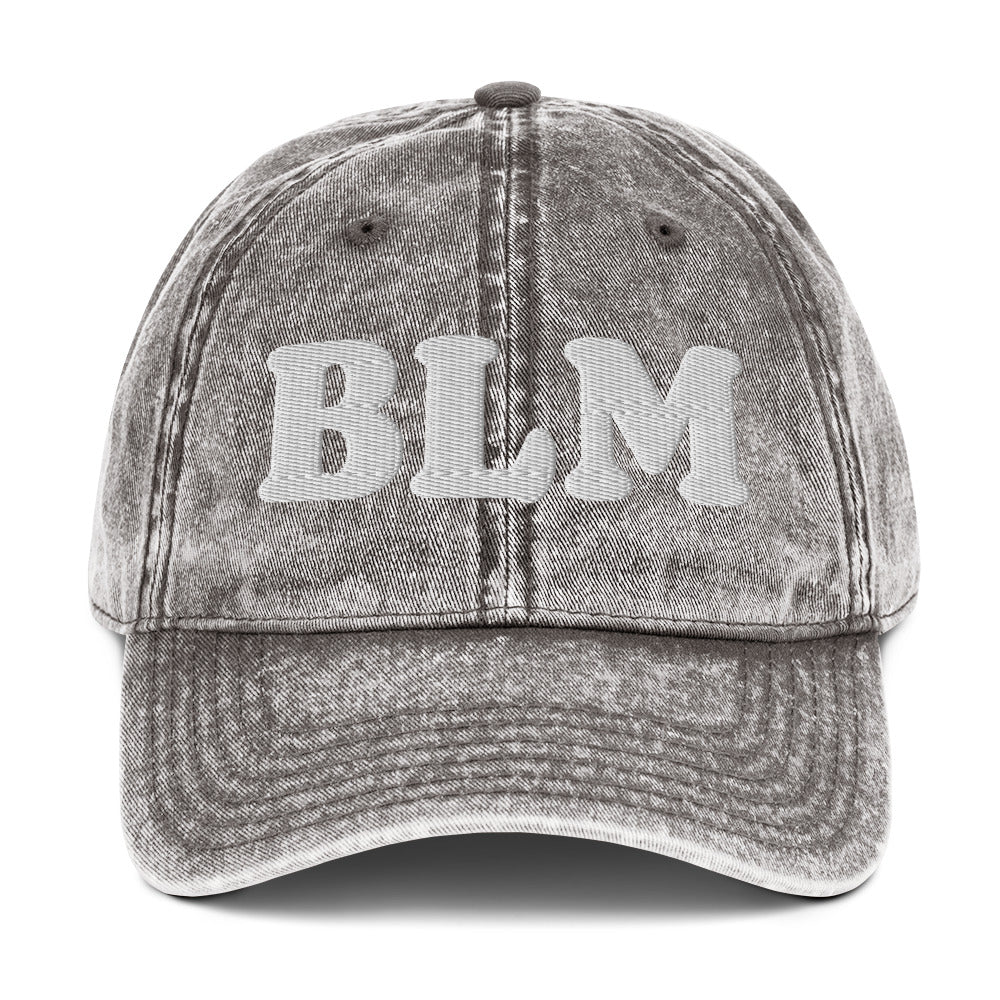 Gray vintage cotton twill cap with raised embroidered “BLM” lettering, faded washed finish, curved brim, and classic dad hat silhouette from Blue Wave USA.