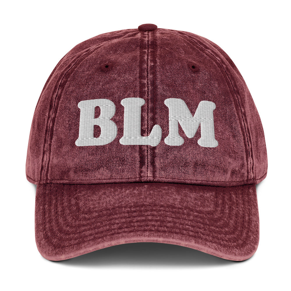 Maroon vintage cotton twill cap with raised embroidered “BLM” lettering, distressed washed fabric, curved brim, and relaxed unstructured fit.