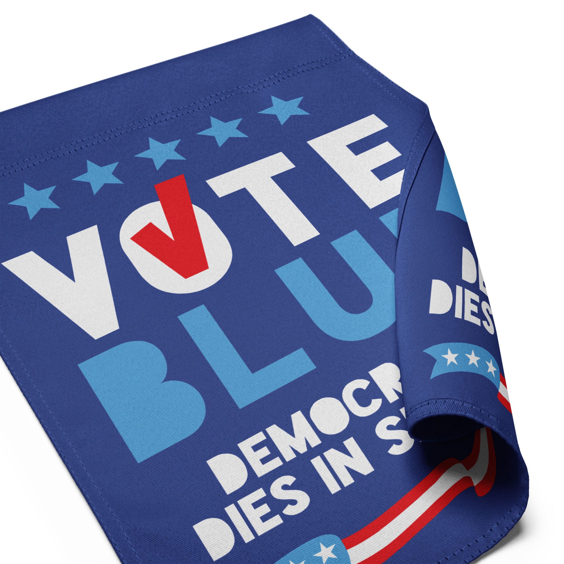 Close-up angled shot of the blue polyester garden flag fabric, showing the high-quality print and the "Democracy Dies in Silence" text.