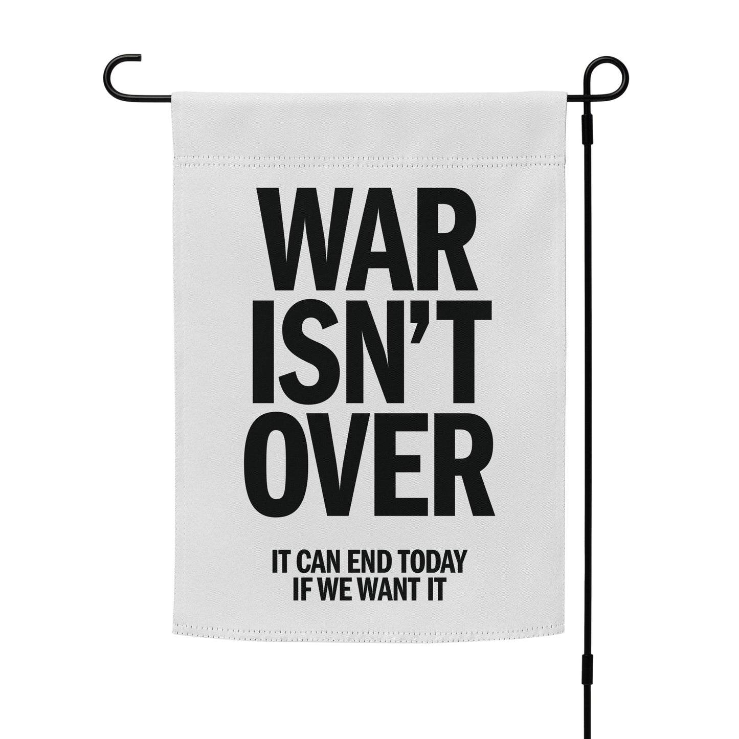 White garden flag mockup on stand with stacked “WAR ISN’T OVER” lettering and smaller anti-war phrase “IT CAN END TODAY IF WE WANT IT.”