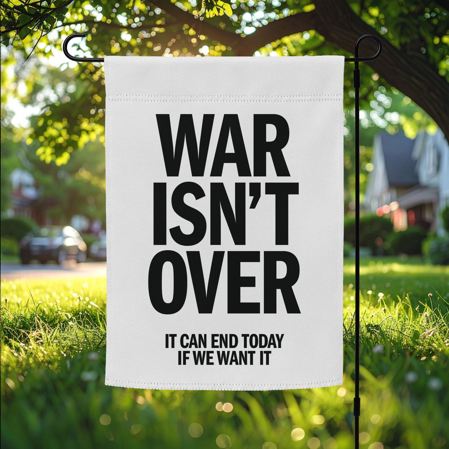 Garden flag featuring bold black “WAR ISN’T OVER” text with “IT CAN END TODAY IF WE WANT IT” below, minimalist anti-war protest outdoor decor.