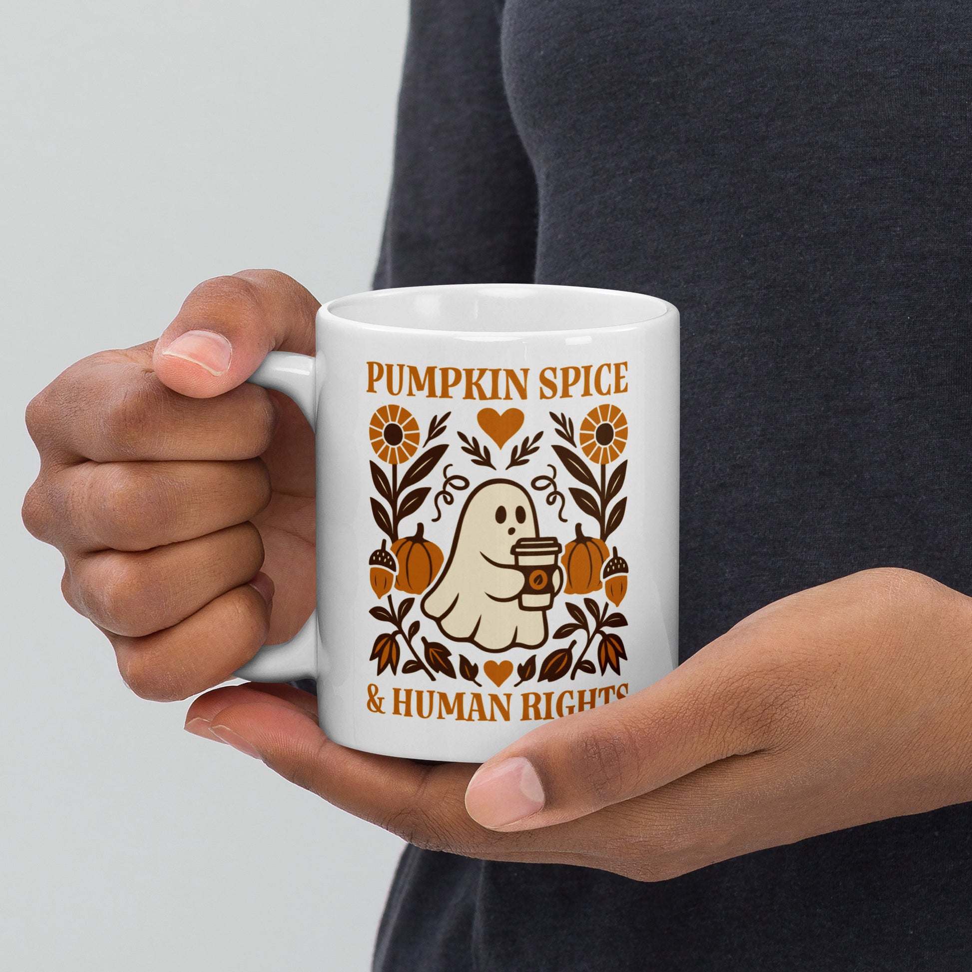 White ceramic mug with “Pumpkin Spice & Human Rights” cozy ghost and pumpkin design, autumn equality drinkware for activists.