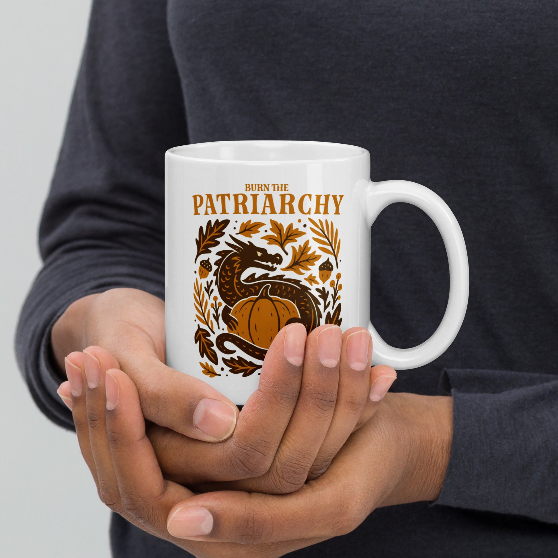 Person holding 11 oz “Burn the Patriarchy” dragon feminist mug, Blue Wave USA progressive home décor for equality and empowerment.