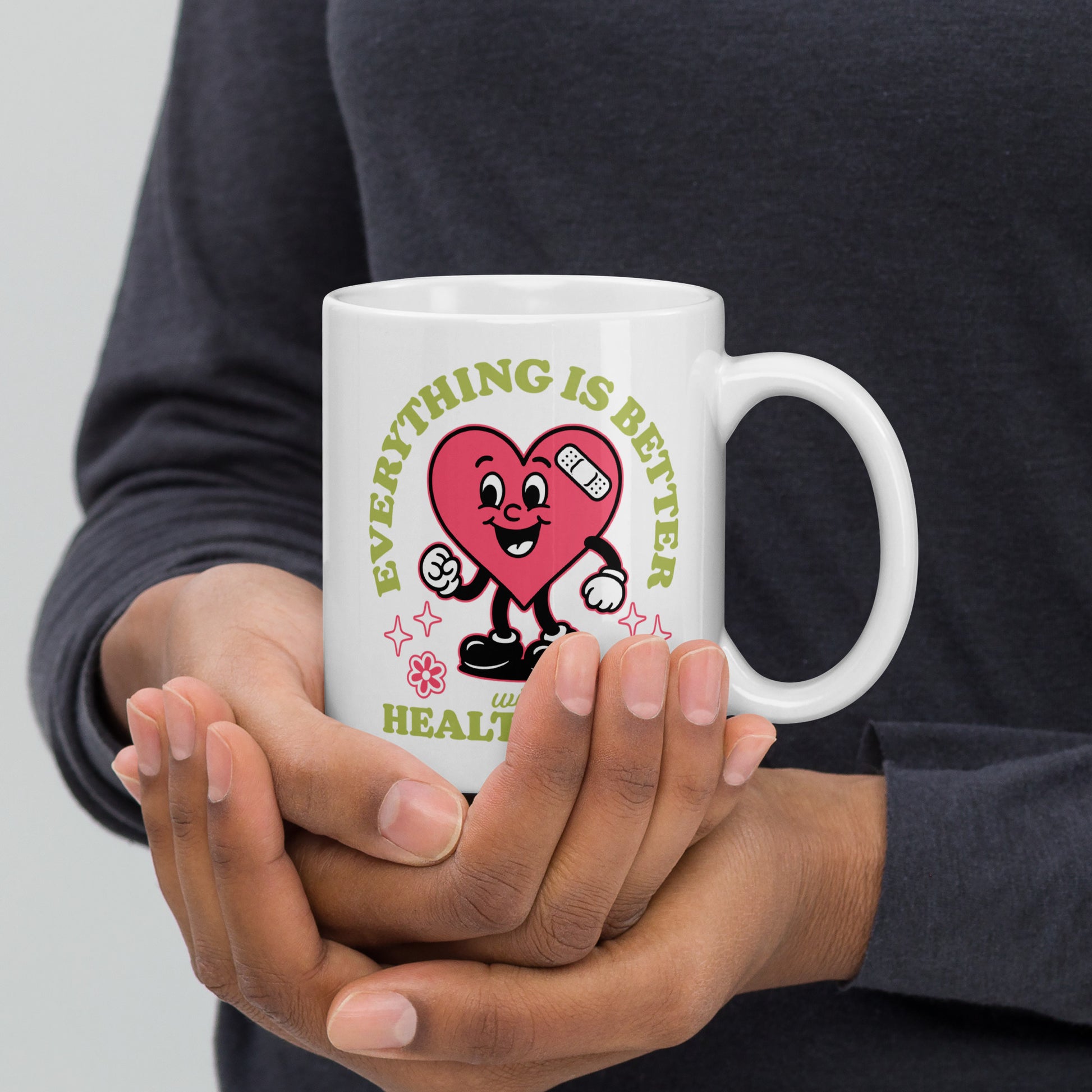 Person holding the 11 oz “Everything Is Better with Healthcare” white glossy mug. The cheerful heart design and pastel green lettering stand out clearly.