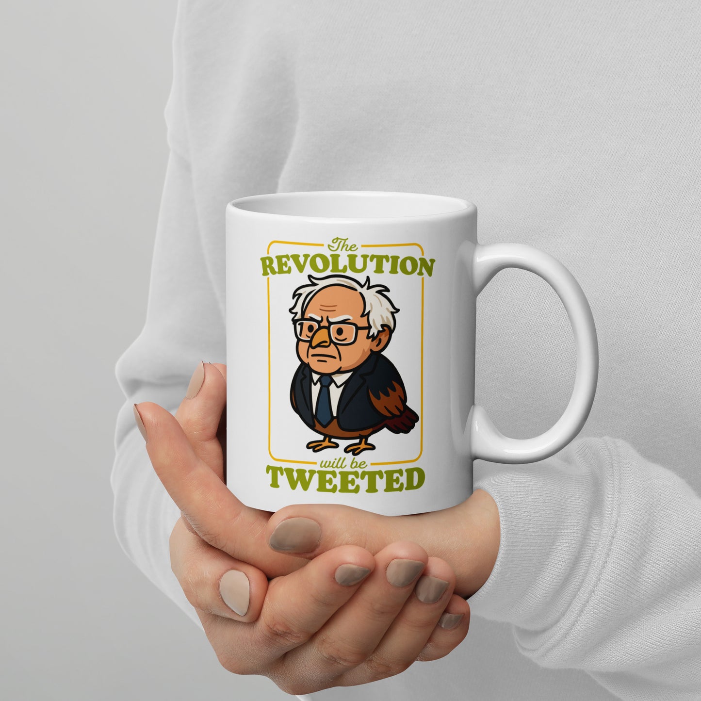 White mug featuring cartoon Birdie Sanders portrait with “The Revolution Will Be Tweeted” text, playful political humor drinkware for progressive gift shoppers.