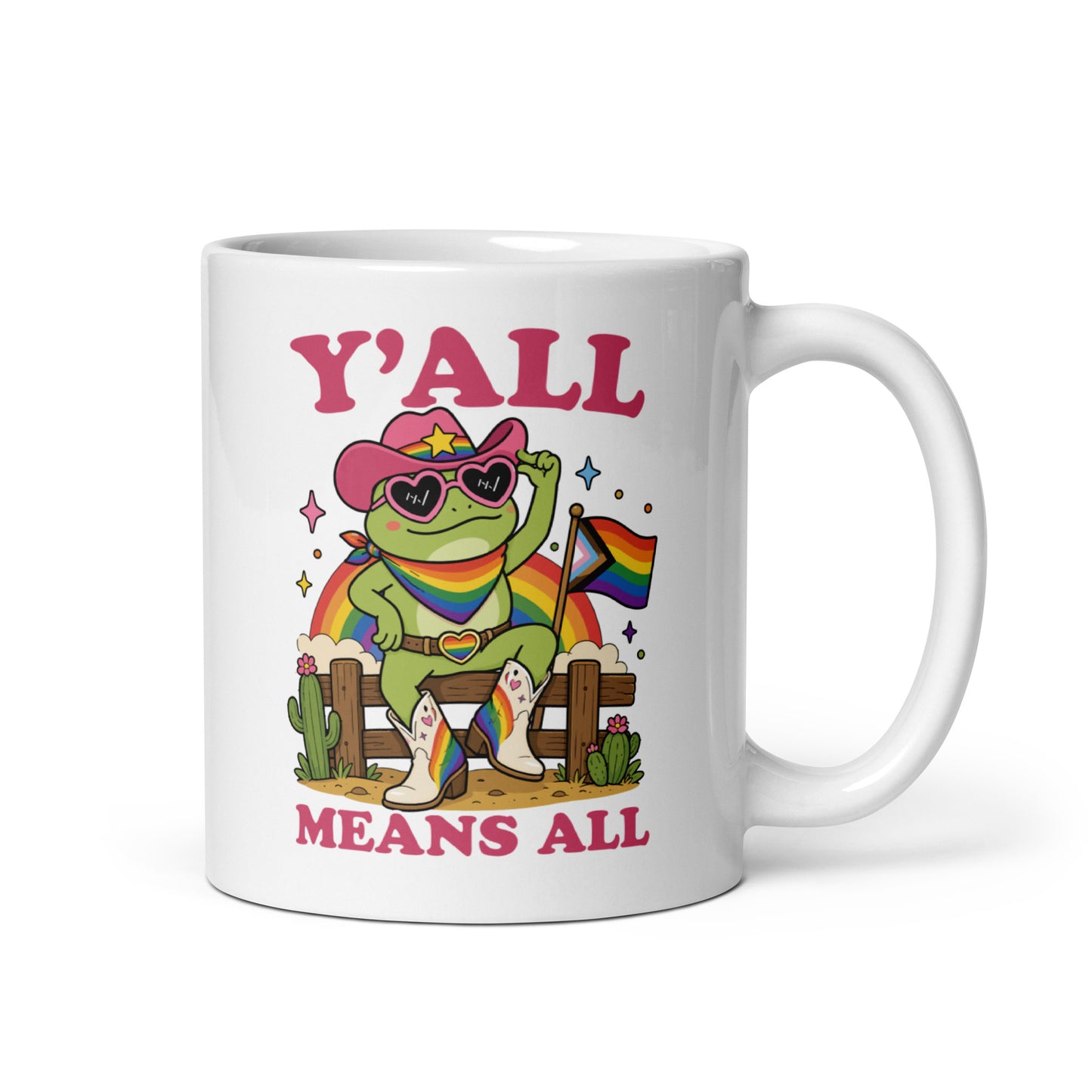 White glossy mug featuring a rainbow cowboy frog in heart-shaped sunglasses holding a pride flag with bold “Y’All Means All” LGBTQ+ pride artwork.