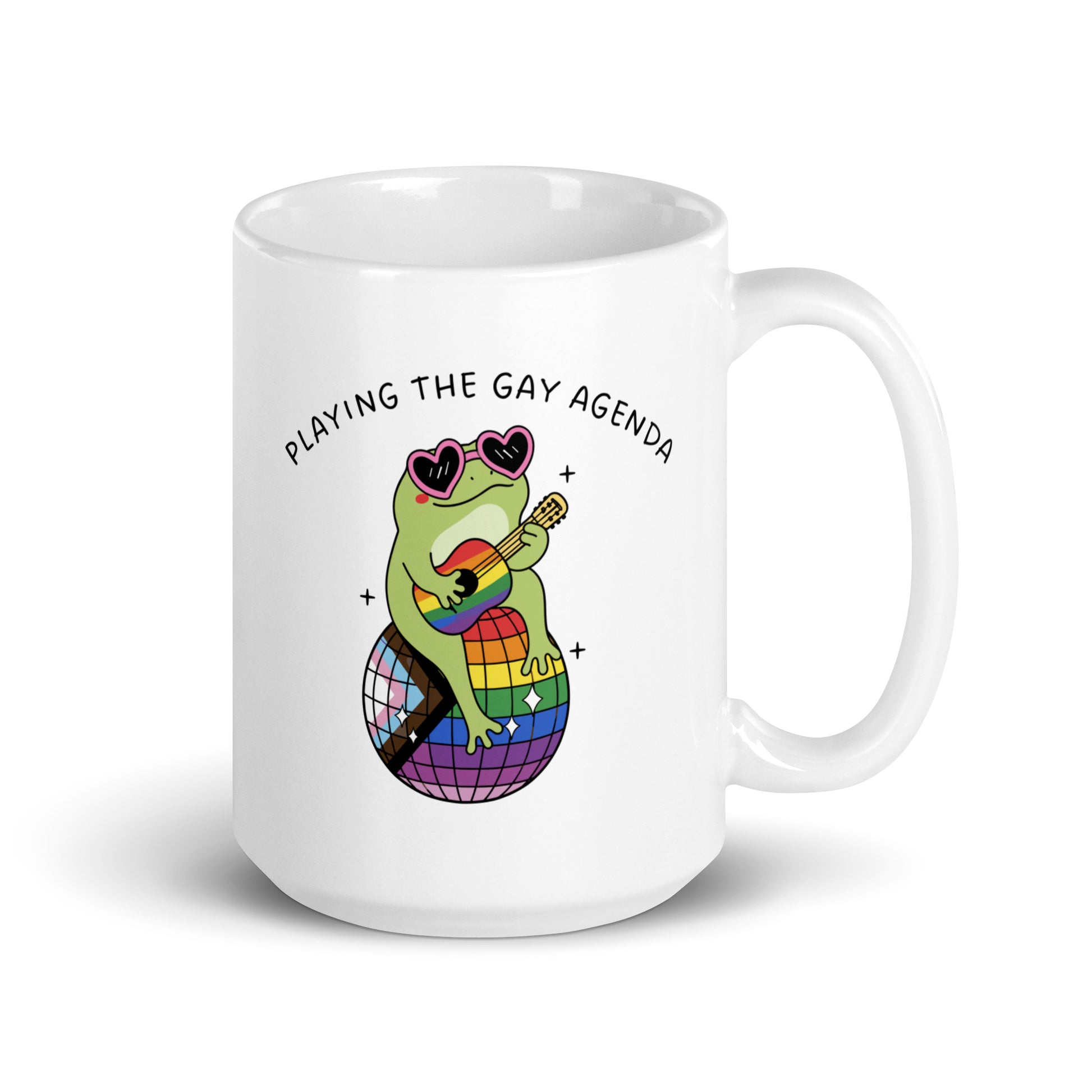 White coffee mug featuring a guitar-playing frog in heart-shaped sunglasses with rainbow accents and vibrant artwork celebrating queer joy and self-expression.