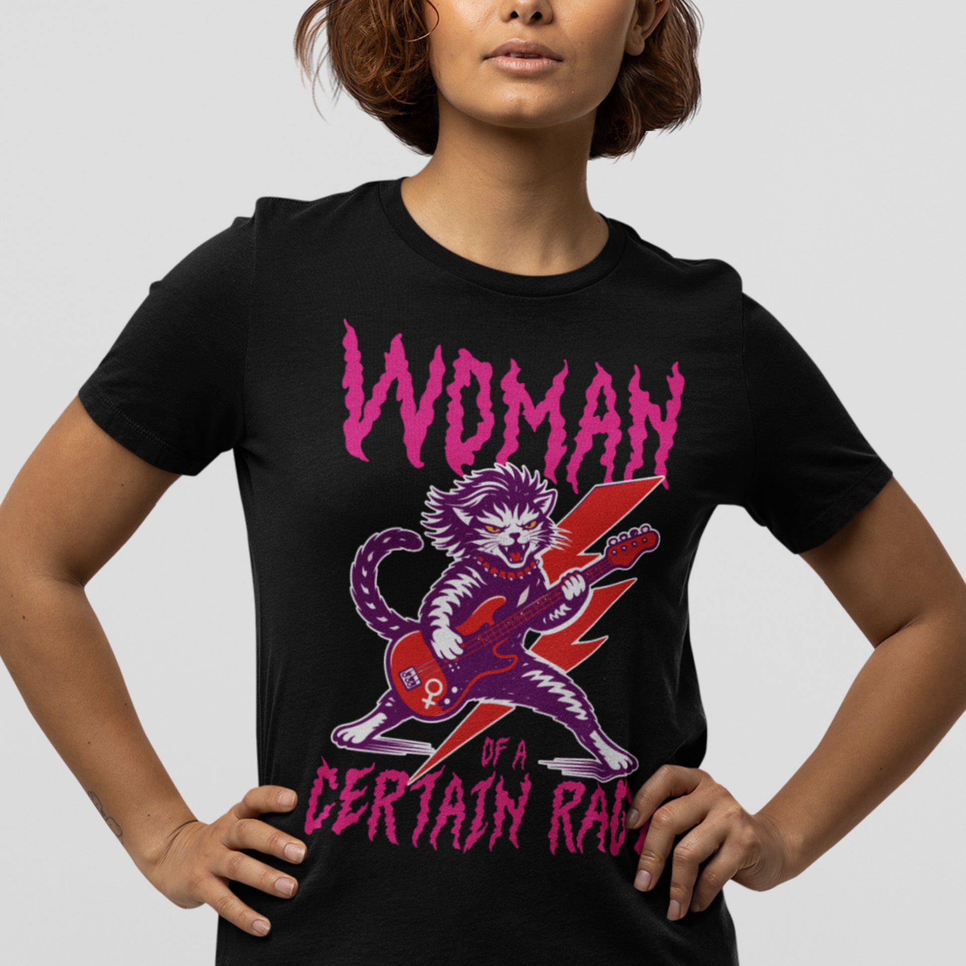 Woman wearing a black women’s relaxed t-shirt featuring a purple rockstar cat playing an electric guitar beneath the phrase “Woman of a Certain Rage,” a bold feminist graphic inspired by punk, rebellion, and women’s empowerment.