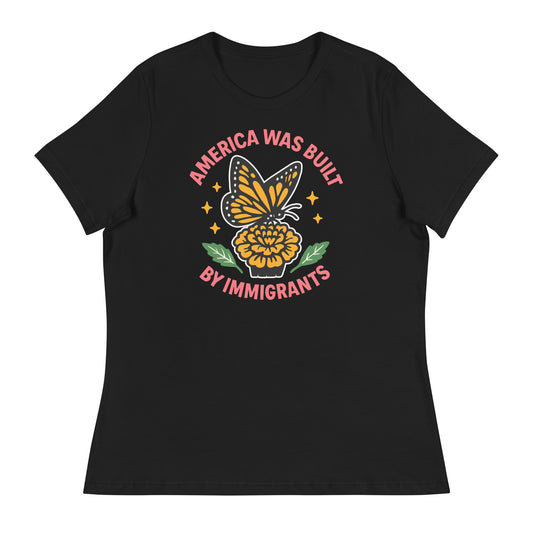 Black “America Was Built by Immigrants” relaxed women’s T-shirt with monarch butterfly and flower design, pro-immigrant feminist apparel.