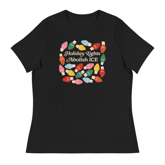 black Women’s Relaxed T-Shirt featuring colorful holiday bulbs surrounding the printed message “Holiday Lights Abolish ICE,” shown in a simple flat lay with a festive activist style.