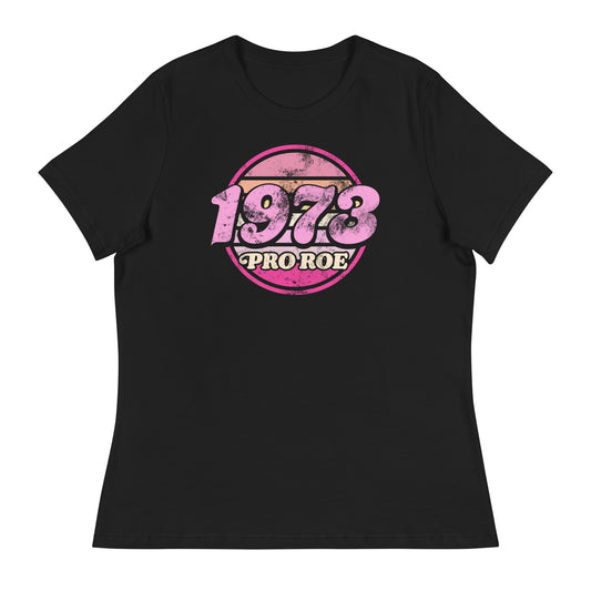 Black women’s relaxed t-shirt displayed flat, featuring a distressed circular badge reading “1973 PRO ROE,” vintage feminist protest graphic centered on the chest.