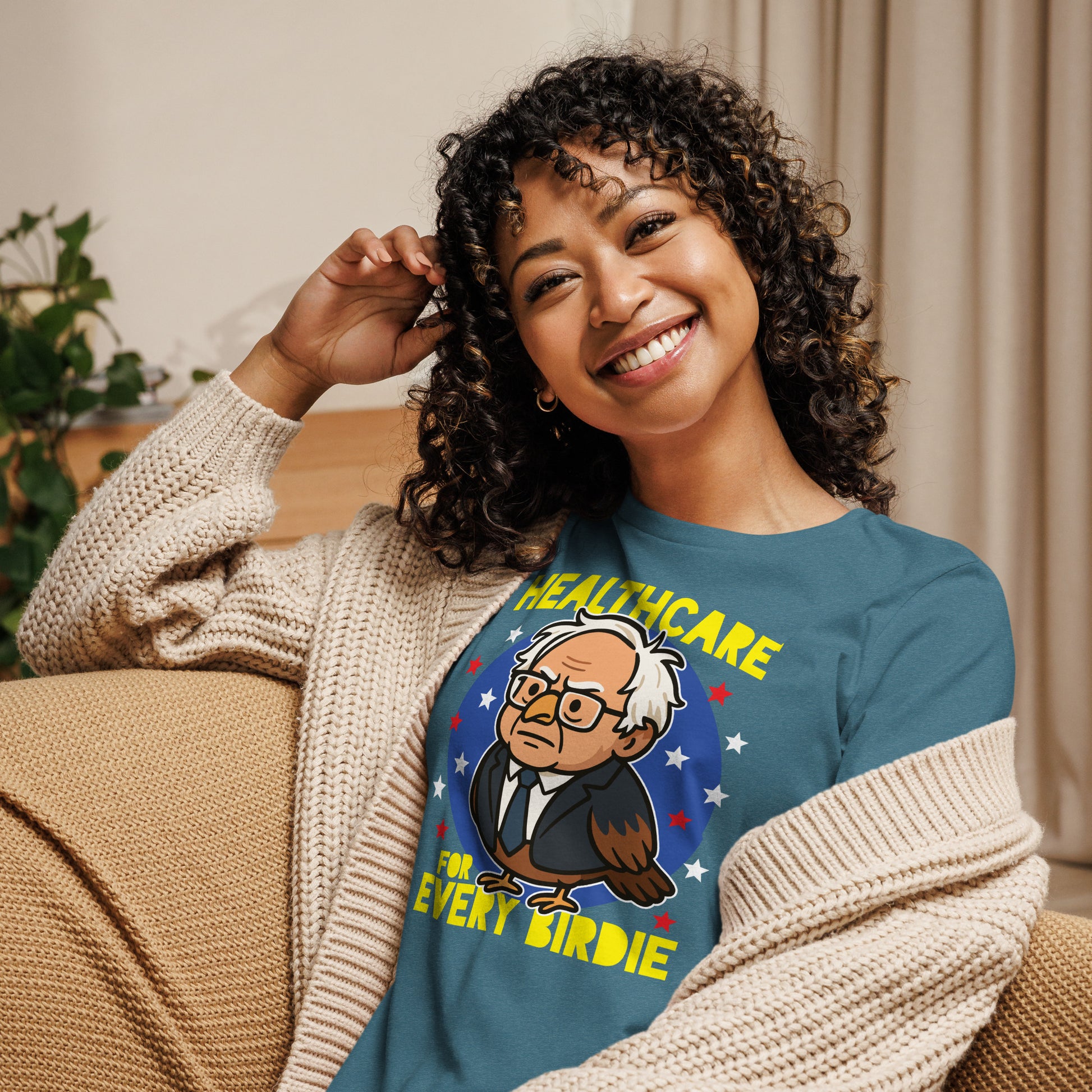 Person wearing a blue women’s relaxed t-shirt featuring the “Healthcare for Every Birdie” owl graphic, a playful design inspired by Birdie Sanders and healthcare advocacy.