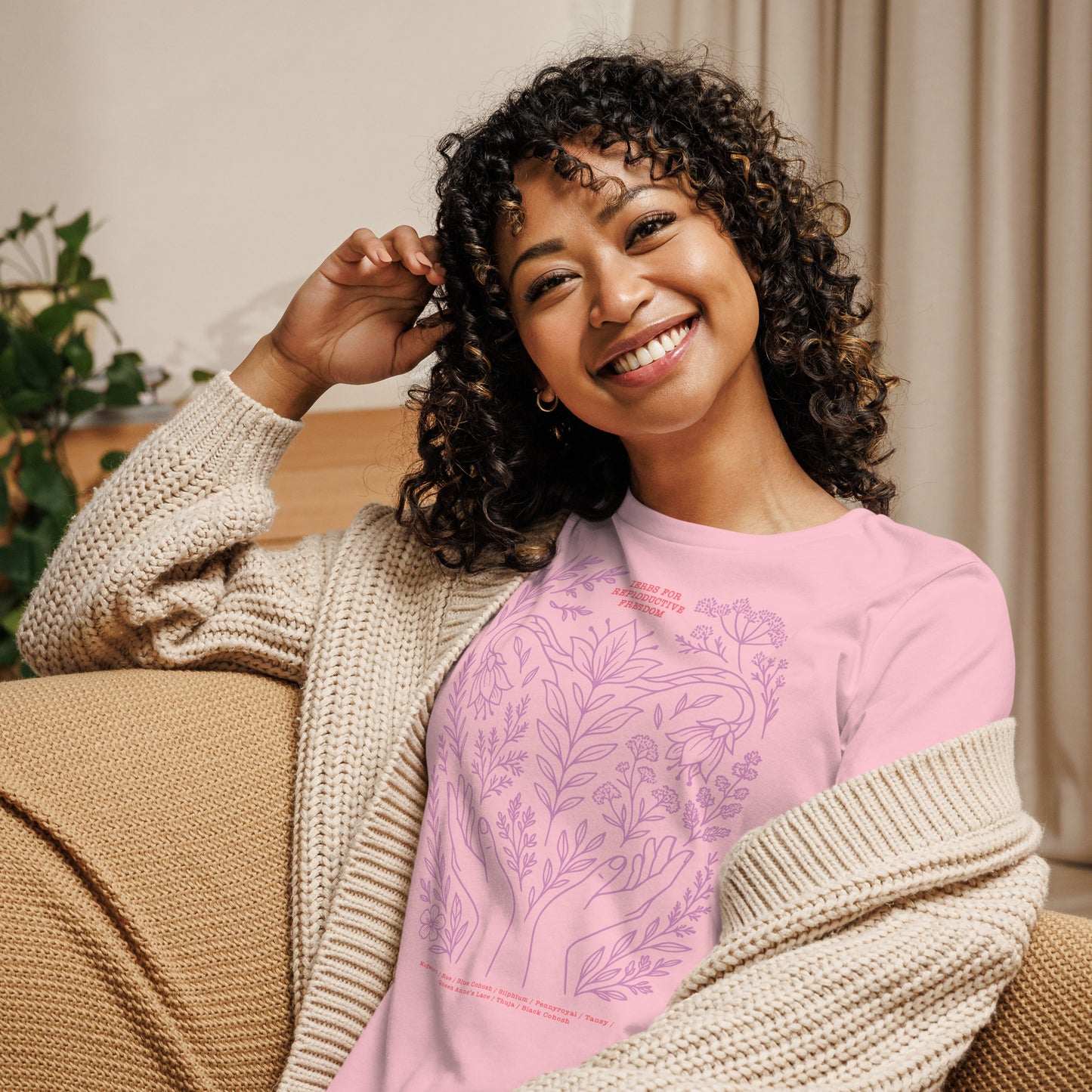 Model wearing the light pink “Herbs for Reproductive Freedom” t-shirt featuring a soft botanical design inspired by traditional reproductive herbs.
