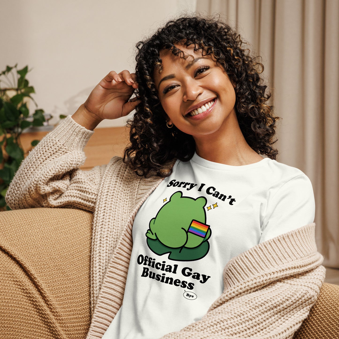 Woman wearing a white pride t-shirt featuring a frog with rainbow flag detail and humorous “Official Gay Business” design celebrating queer joy and self-expression.