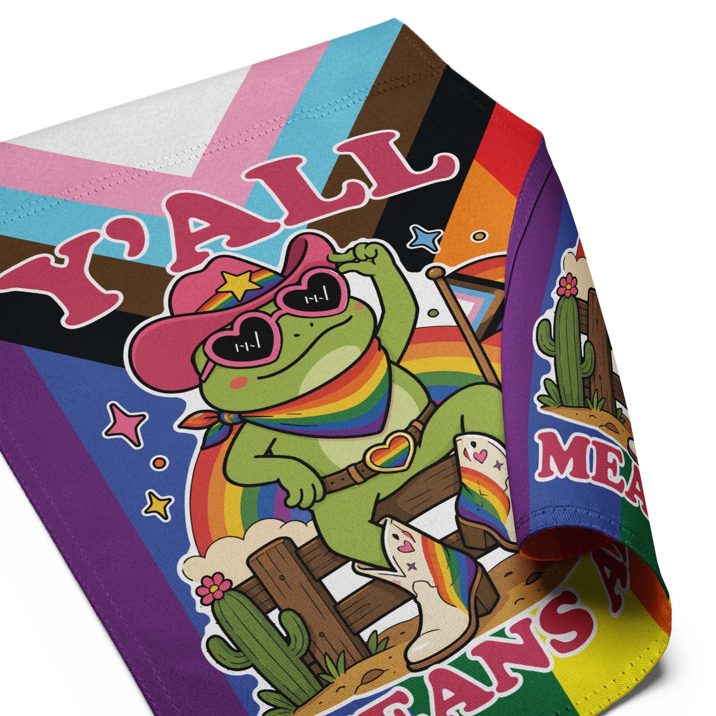 Folded garden flag showing vibrant LGBTQ+ pride artwork with a rainbow cowboy frog, pride flag accents, and bold “Y’All Means All” message.